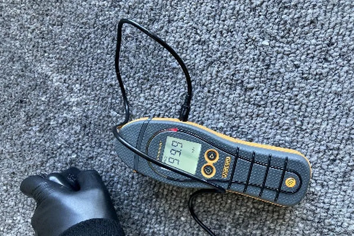 Pin-mode moisture reading taken on saturated carpet