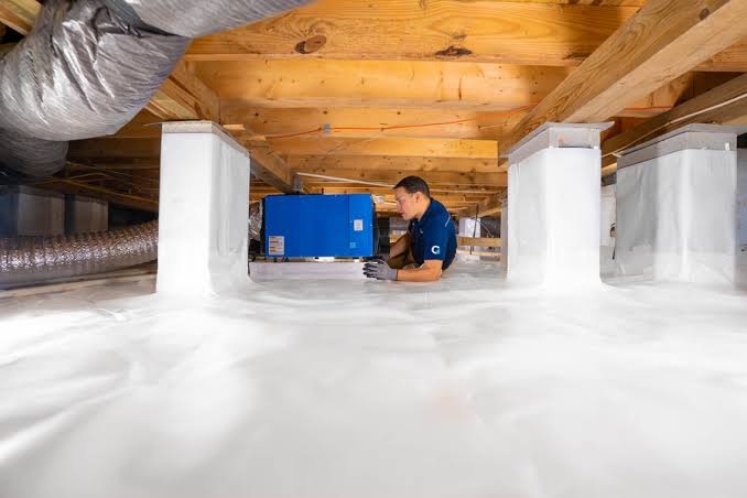 Technician inspecting a sealed crawl space with vapour barrier in an Australian home