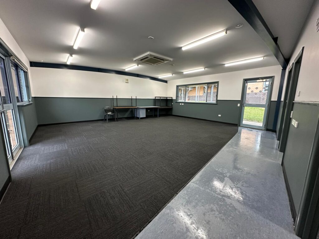 Restored withdrawal space with fresh wall linings, coat rack and dry carpet ready for return to service