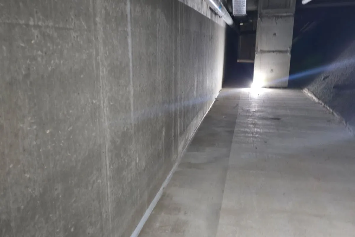 Technician working along the concrete confined space access corridor