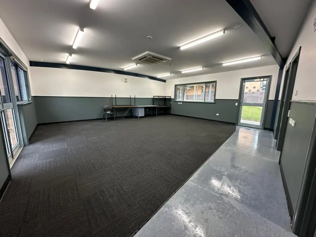Restored withdrawal space with fresh wall linings, coat rack and dry carpet ready for return to service